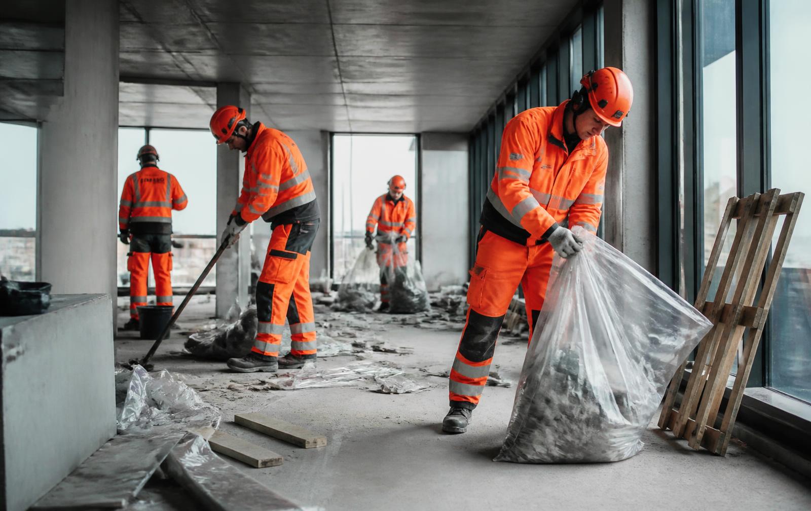 Mandskab fra Noda Byg 23 ApS rydder op på en byggeplads